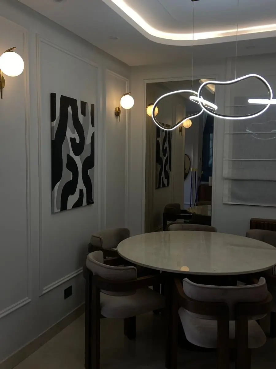 Salle à manger d'une villa livrée à Dar Bouazza : table ronde en marbre, suspension lumineuse