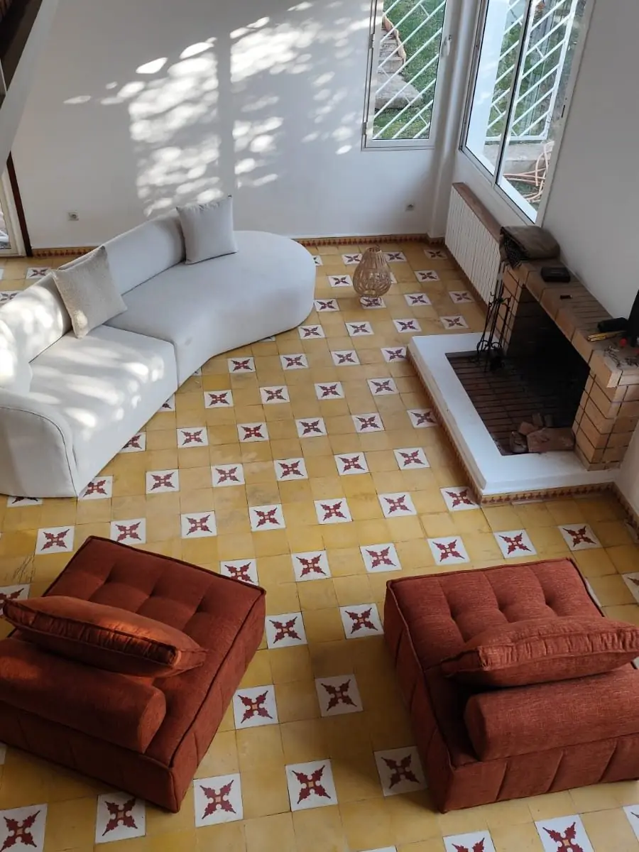 Salon livré : canapé courbe et fauteuils rouille, villa à Hay Riad